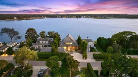 an aerial view of residential houses with outdoor space and lake view