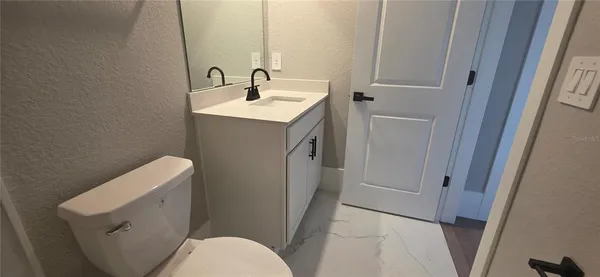 a bathroom with a sink a toilet and vanity