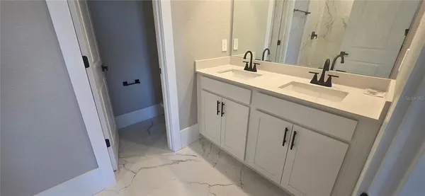 a bathroom with a double vanity sink and mirror