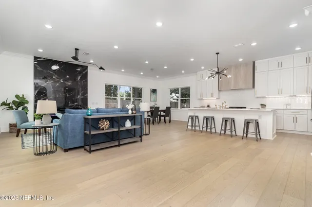 a kitchen with stainless steel appliances kitchen island granite countertop a stove a sink a dining table and chairs