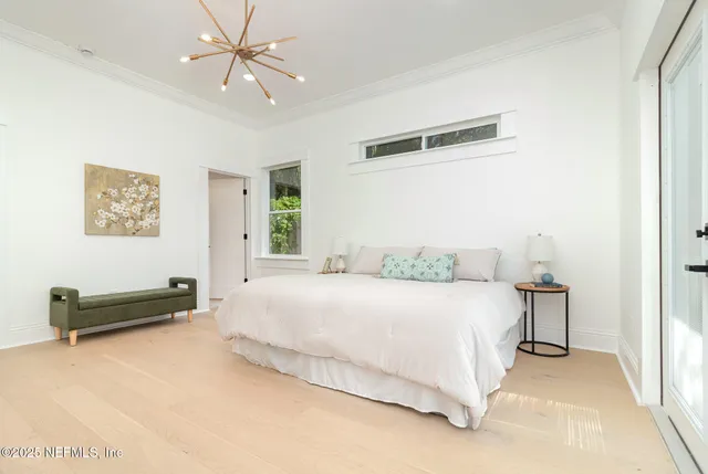 a bedroom with a bed and a chandelier