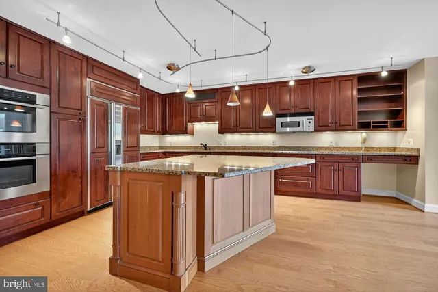 a kitchen with stainless steel appliances granite countertop a stove a sink dishwasher a refrigerator and a microwave oven