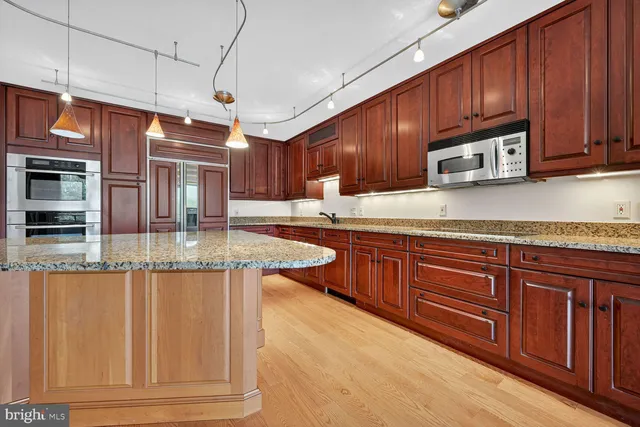 a kitchen with kitchen island granite countertop wooden cabinets a sink and dishwasher