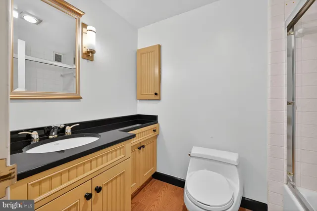 a bathroom with a granite countertop toilet sink and mirror