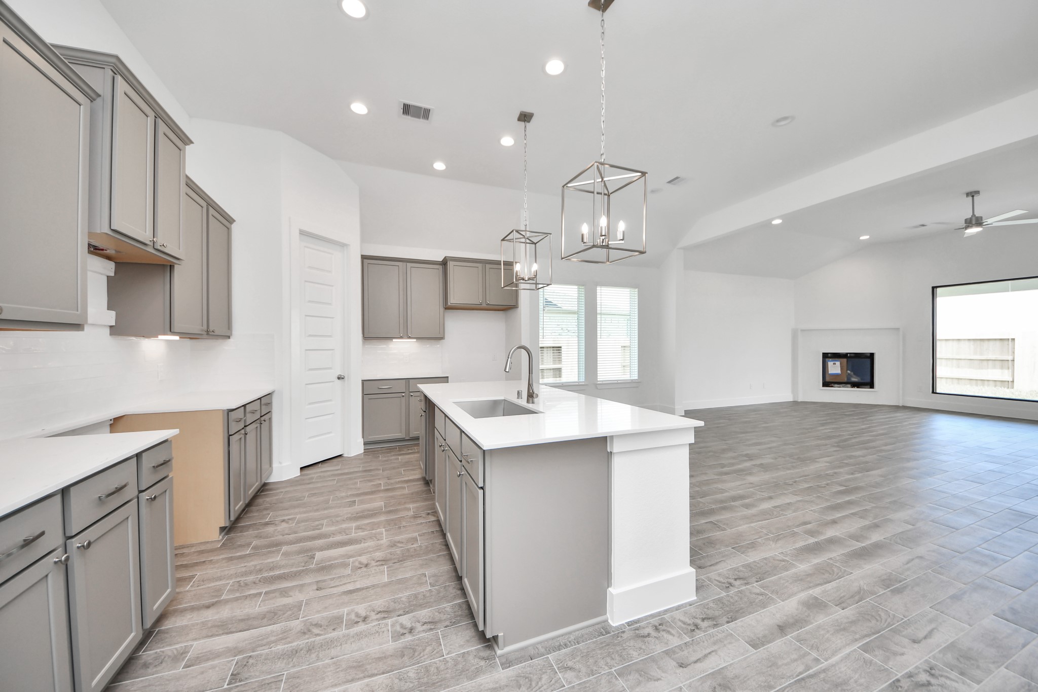 3046 Native Spg Drive Spring, TX 77373 - Photo 13 of 35 Step into a dream realized with this generously spacious kitchen! A massive granite island takes center stage, complemented by high ceilings and soft-close cabinets. The granite countertops, stainless steel appliances, sleek tile backsplash, and recessed lighting complete the elegant design. Sample photo of completed home with similar floor plan. Actual colors and selections may vary.