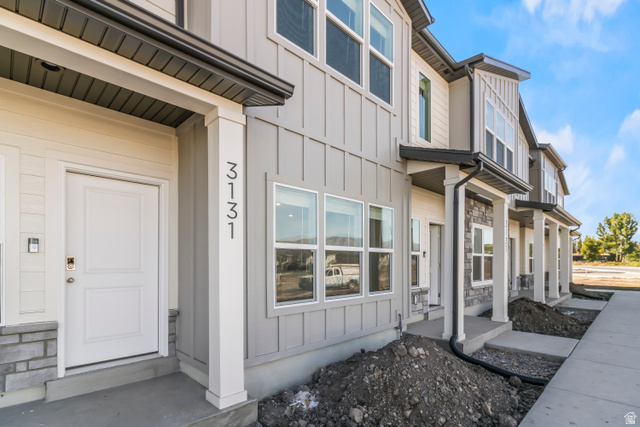 3017 South 265th Street West Logan, UT 84321 - Photo 3 of 22 Contemporary multi-level townhome featuring a board and batten facade, white entry door, and large windows