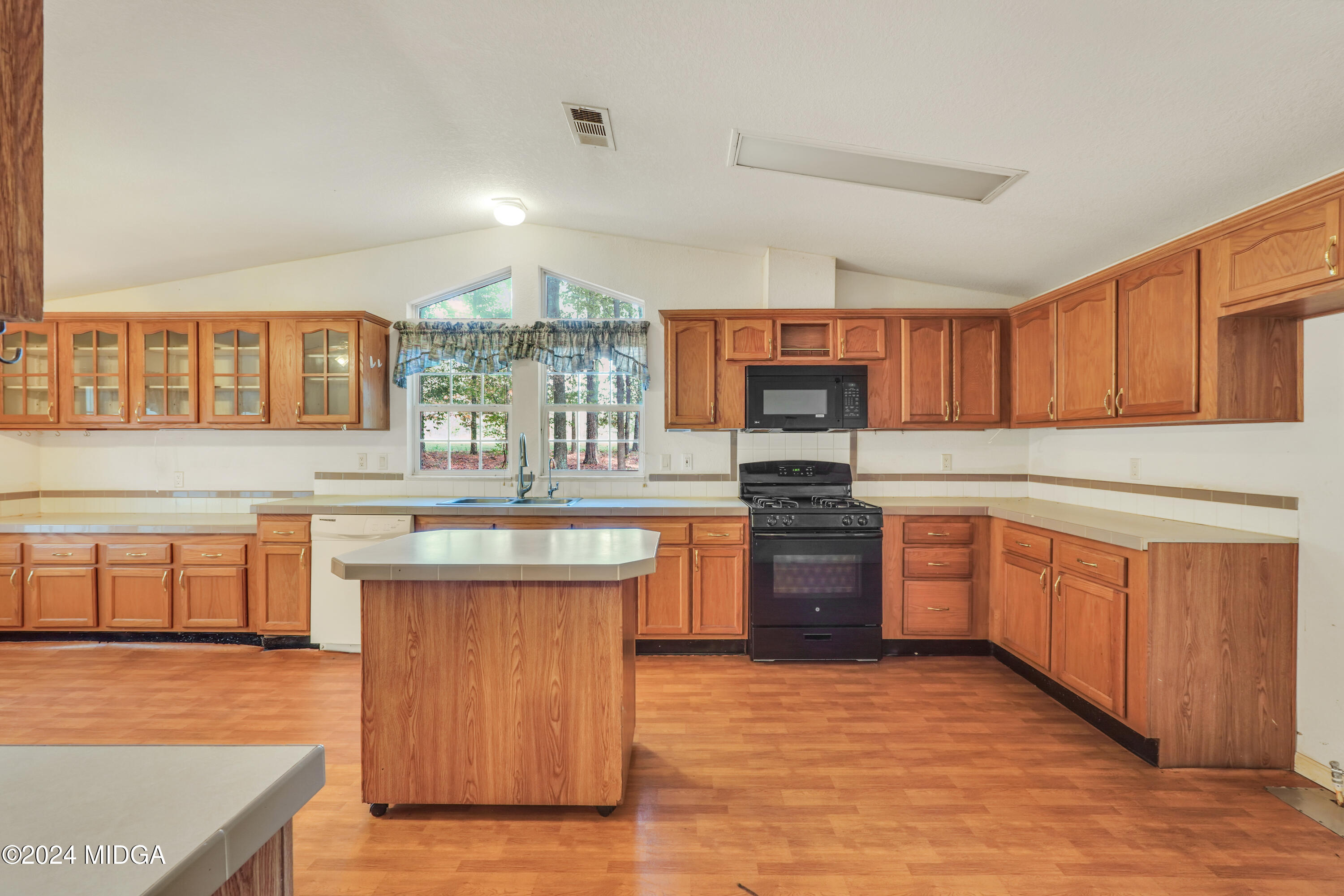 615 Fuller Road Culloden, GA 31016 - Photo 11 of 37 a kitchen with stainless steel appliances granite countertop a sink dishwasher stove and oven with wooden cabinets