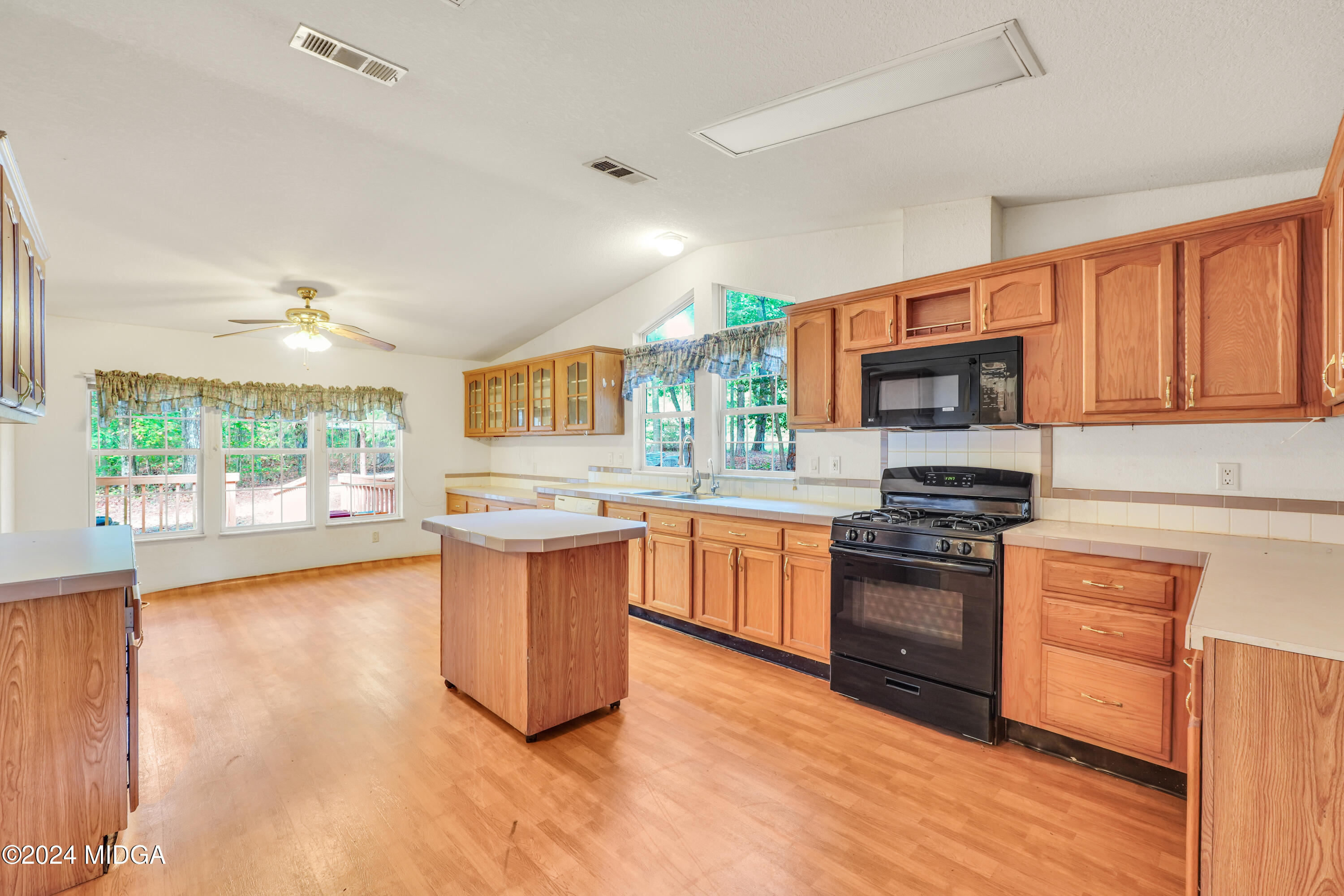 615 Fuller Road Culloden, GA 31016 - Photo 7 of 37 a kitchen with stainless steel appliances granite countertop a stove top oven a sink dishwasher a microwave oven and a dining table with wooden floor