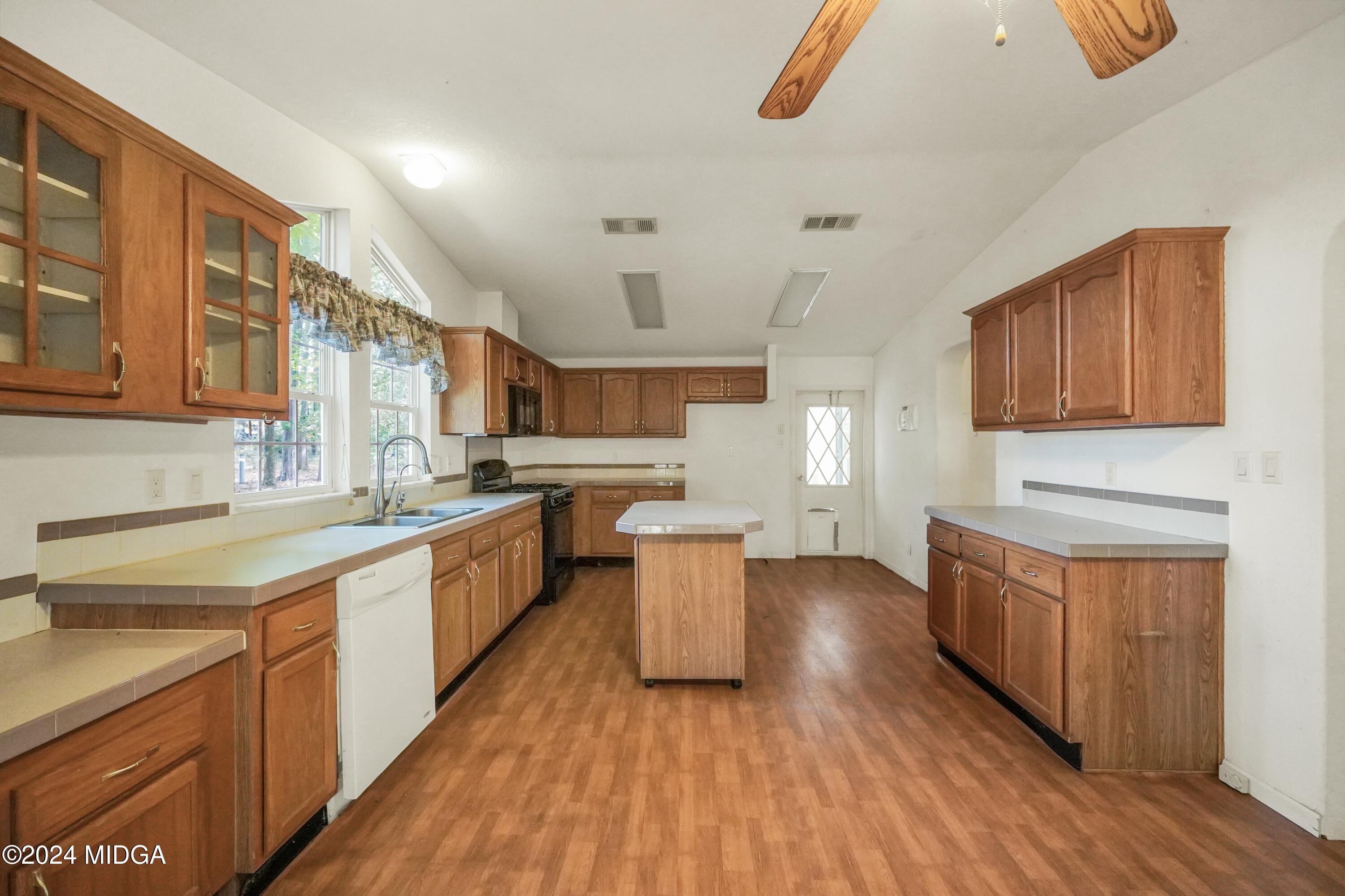 615 Fuller Road Culloden, GA 31016 - Photo 10 of 37 a kitchen with a sink and wooden cabinets