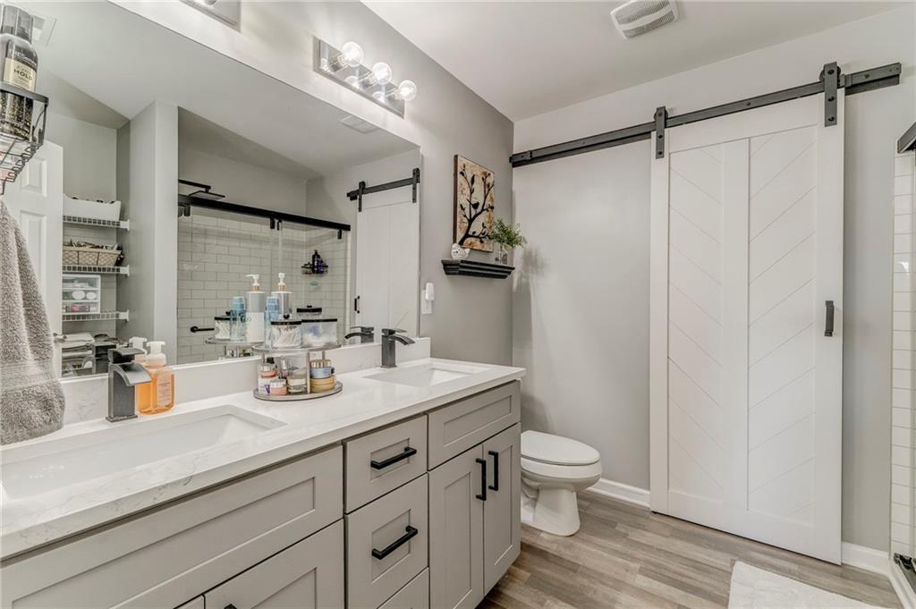 803 Riverside Drive Calhoun, GA 30701 - Photo 32 of 63 a bathroom with a granite countertop sink a toilet a mirror and shower