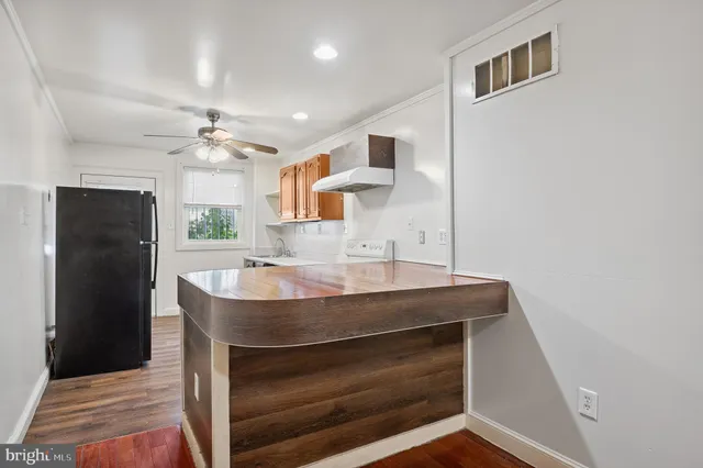 a room with stainless steel appliances kitchen island a table and chairs