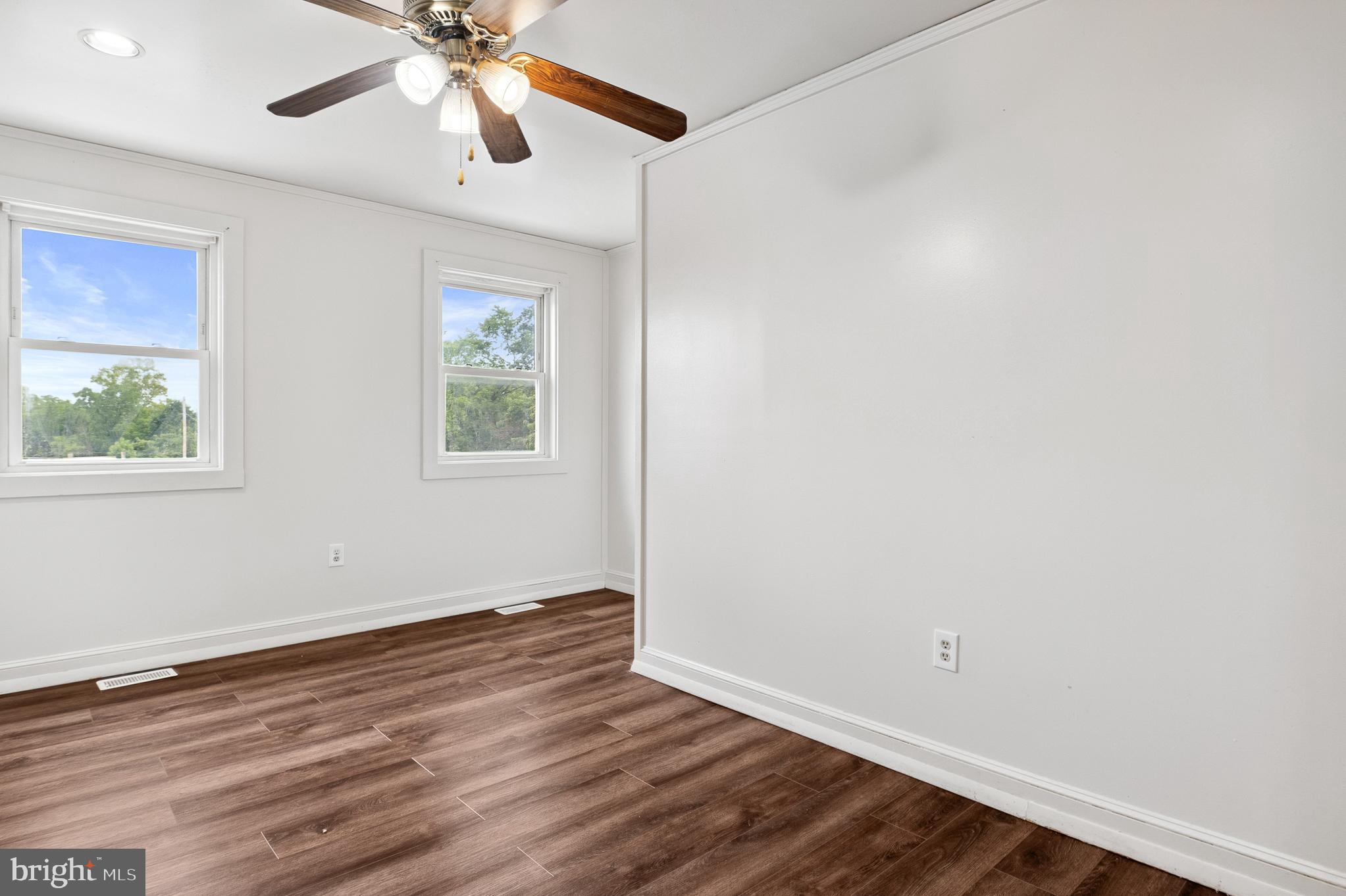 636 South Monroe Street Baltimore, MD 21223 - Photo 20 of 39 an empty room with wooden floor chandelier fan and windows