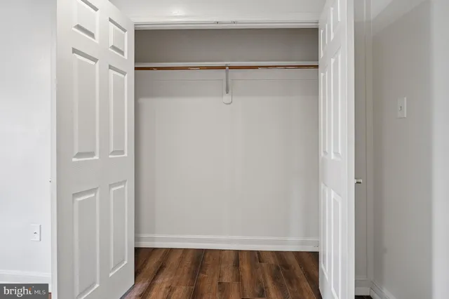 a view of a room with wooden floor and ceiling fan