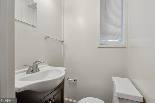 a bathroom with a sink a toilet and a mirror