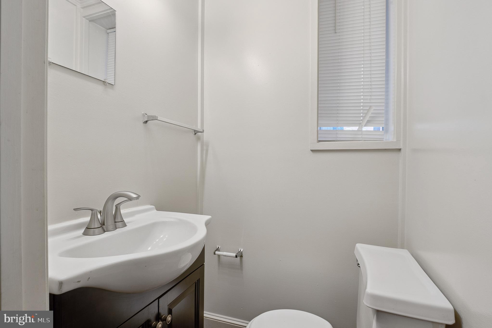 636 South Monroe Street Baltimore, MD 21223 - Photo 10 of 39 a bathroom with a sink a toilet and a mirror