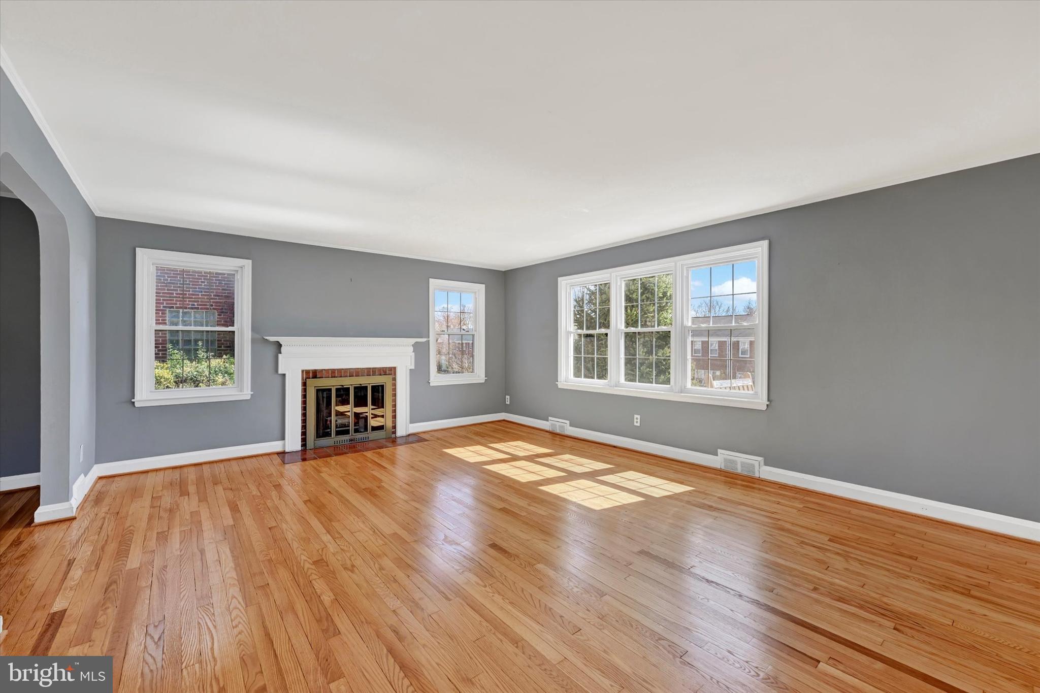 8122 Glen Gary Road Towson, MD 21286 - Photo 6 of 48 an empty room with windows fireplace and wooden floor