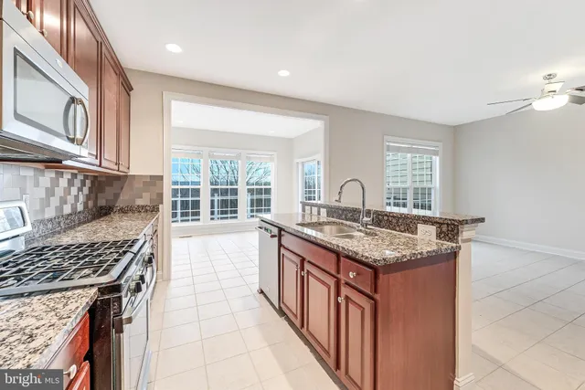 a kitchen with granite countertop wooden cabinets and stainless steel appliances