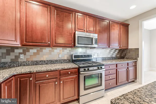a kitchen with stainless steel appliances granite countertop a sink stove and cabinets