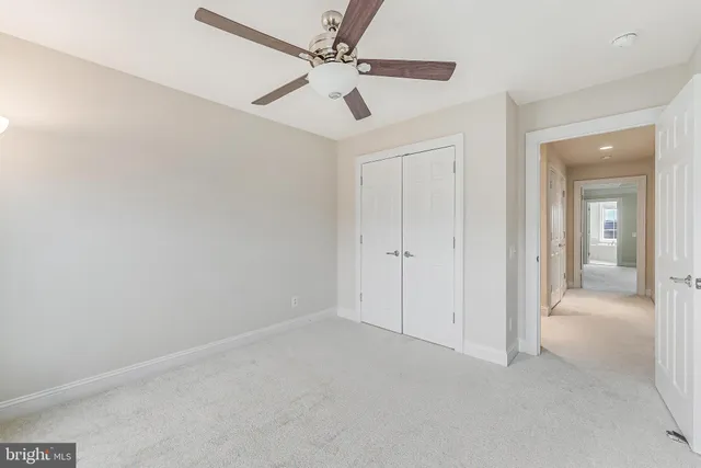 a view of a livingroom with a ceiling fan and window