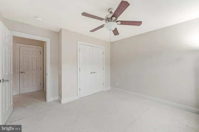 a view of an empty room with wooden floor and stairs
