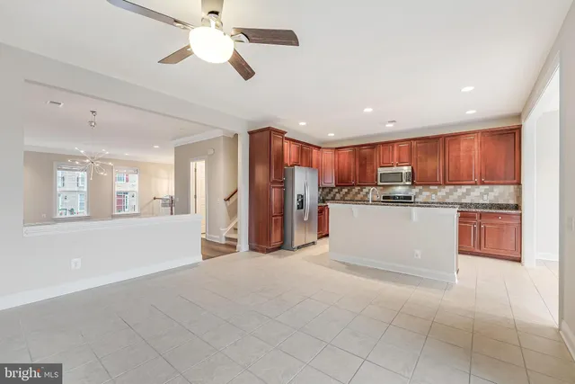 a kitchen with stainless steel appliances granite countertop a refrigerator a stove a sink and a microwave