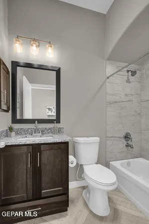 a bathroom with a granite countertop toilet a sink and a mirror