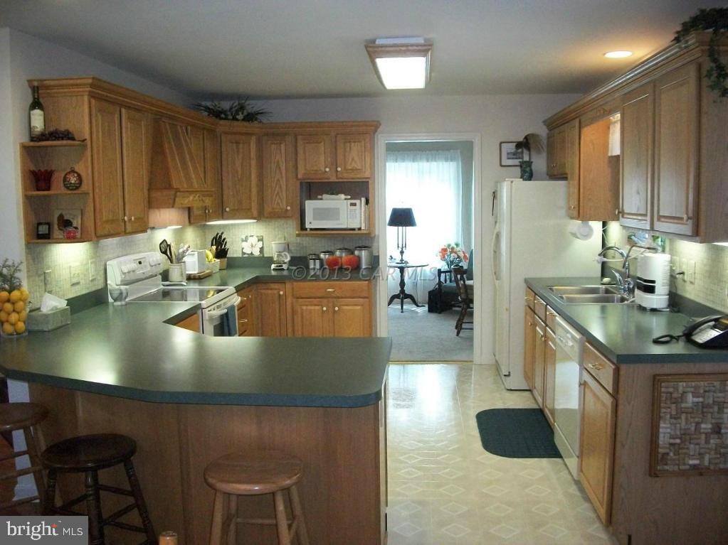 273 Windjammer Road Ocean Pines, MD 21811 - Photo 11 of 33 a kitchen with stainless steel appliances granite countertop a sink a stove and a refrigerator