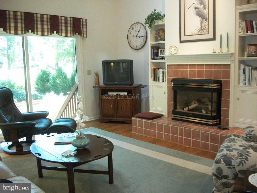 273 Windjammer Road Ocean Pines, MD 21811 - Photo 7 of 33 a living room with furniture a flat screen tv and a fireplace