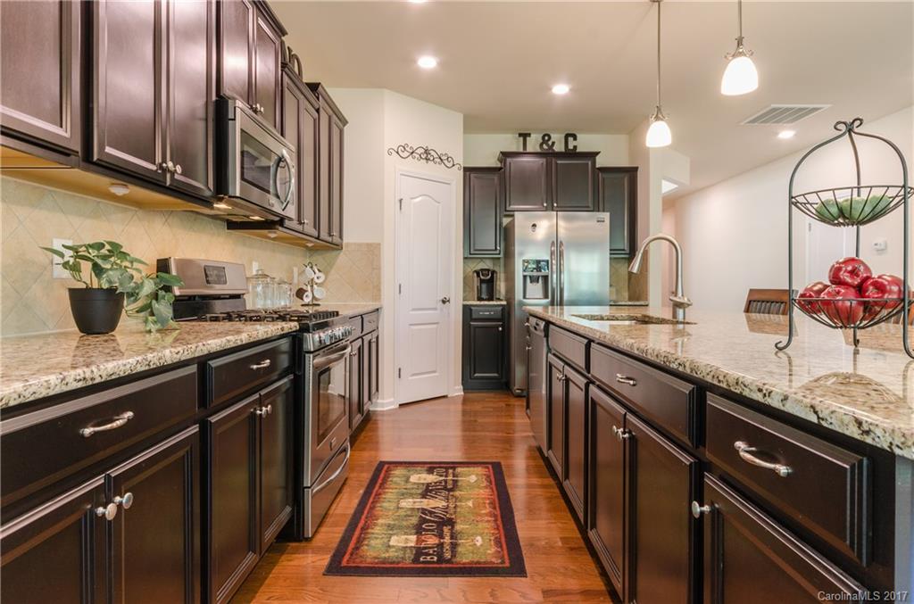 4155 Perth Road Indian Land, SC 29707 - Photo 5 of 24 a kitchen with stainless steel appliances granite countertop a sink a stove top oven a counter space and cabinets