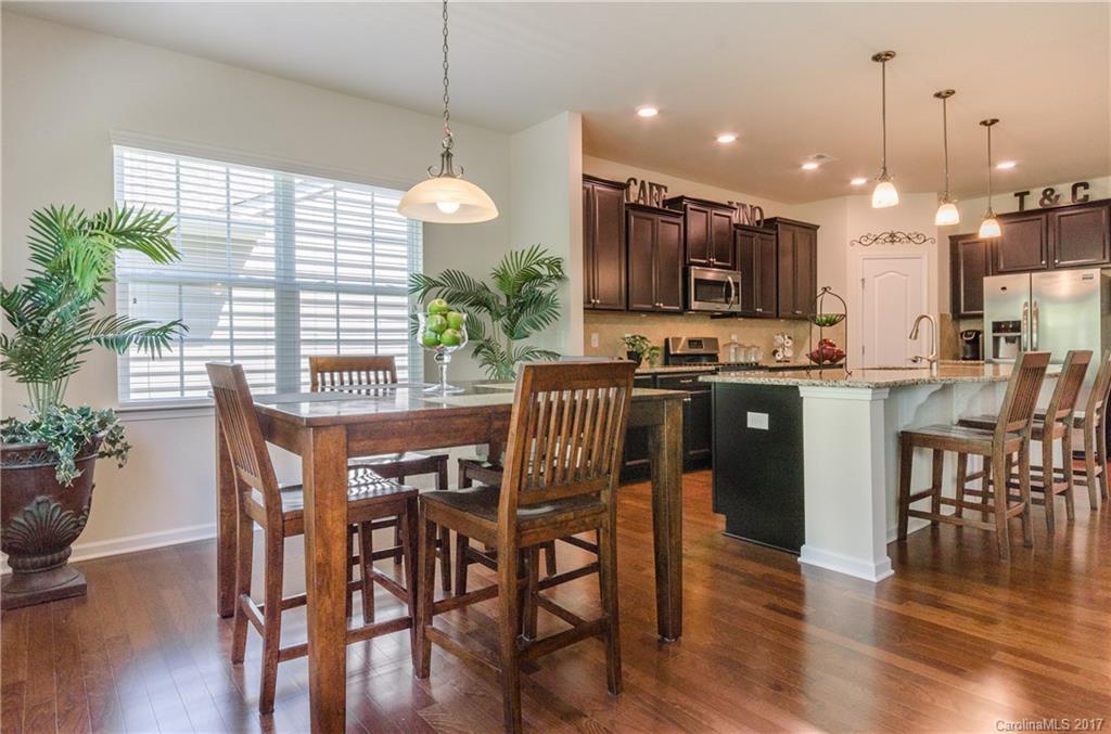 4155 Perth Road Indian Land, SC 29707 - Photo 6 of 24 a kitchen with kitchen island a dining table chairs and a potted plant