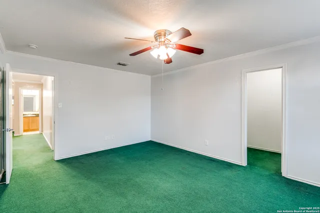 a view of an empty room with window and a kitchen