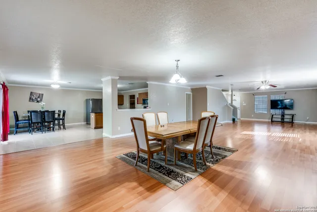 a dining room with furniture wooden floor a glass table and a fireplace