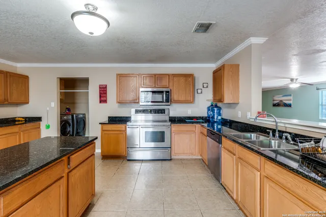 a kitchen with stainless steel appliances granite countertop a stove sink and cabinets