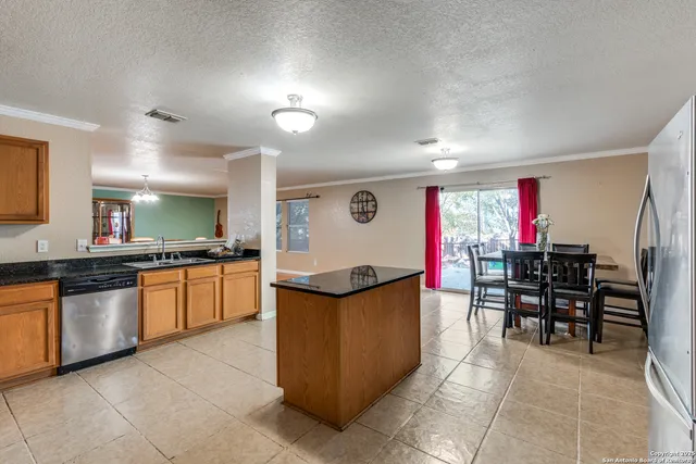 a kitchen with stainless steel appliances granite countertop a table and chairs