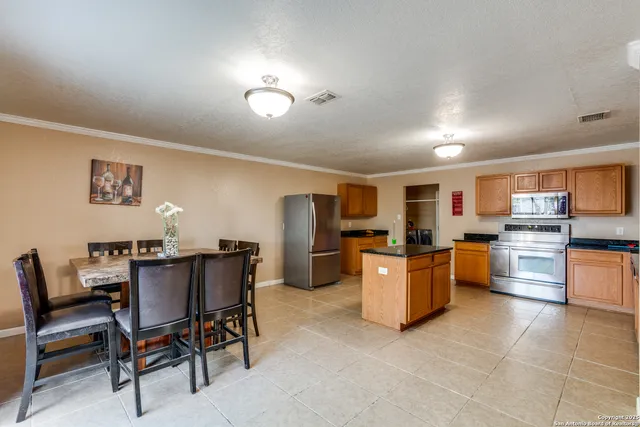 a view of a dining room with furniture and a kitchen