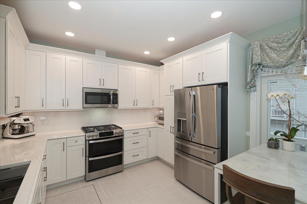 3481 Ravinia Circle Aurora, IL 60504 - Photo 8 of 28 a kitchen with stainless steel appliances a refrigerator sink and stove top oven