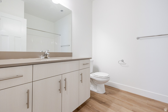 4664 South 680th West, Unit S304 Mapleton, UT 84664 - Photo 6 of 16 Bathroom featuring a vanity with an integrated sink, a large wall-mounted mirror, and wood-finish flooring