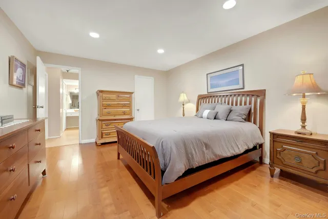 a bedroom with a bed and a lamp with the wooden floor