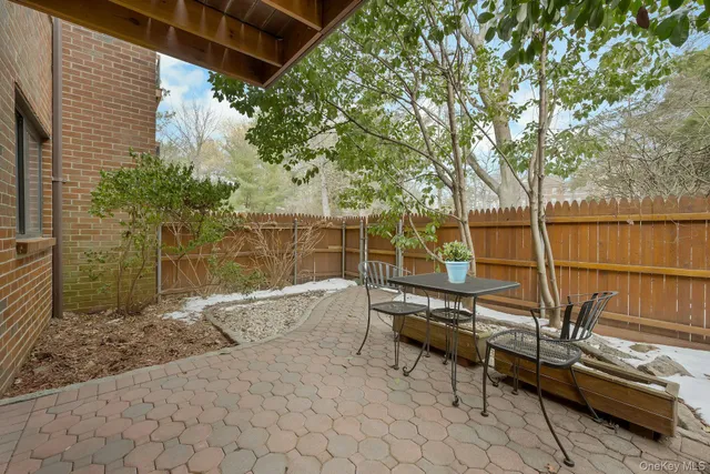 a roof deck with table and chairs and potted plants