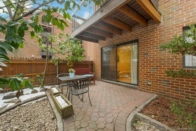 a backyard with table and chairs with potted plants