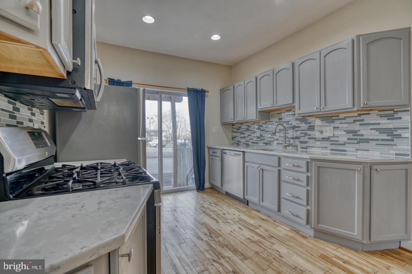 1754 Clarkson Street Baltimore, MD 21230 - Photo 12 of 35 a kitchen with stainless steel appliances granite countertop a stove a sink dishwasher and cabinets with wooden floor