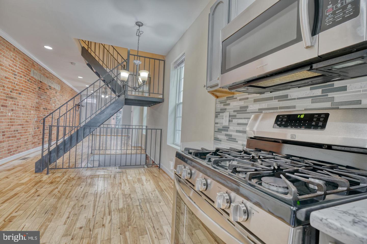1754 Clarkson Street Baltimore, MD 21230 - Photo 14 of 35 a kitchen with wooden floors and a stove top oven