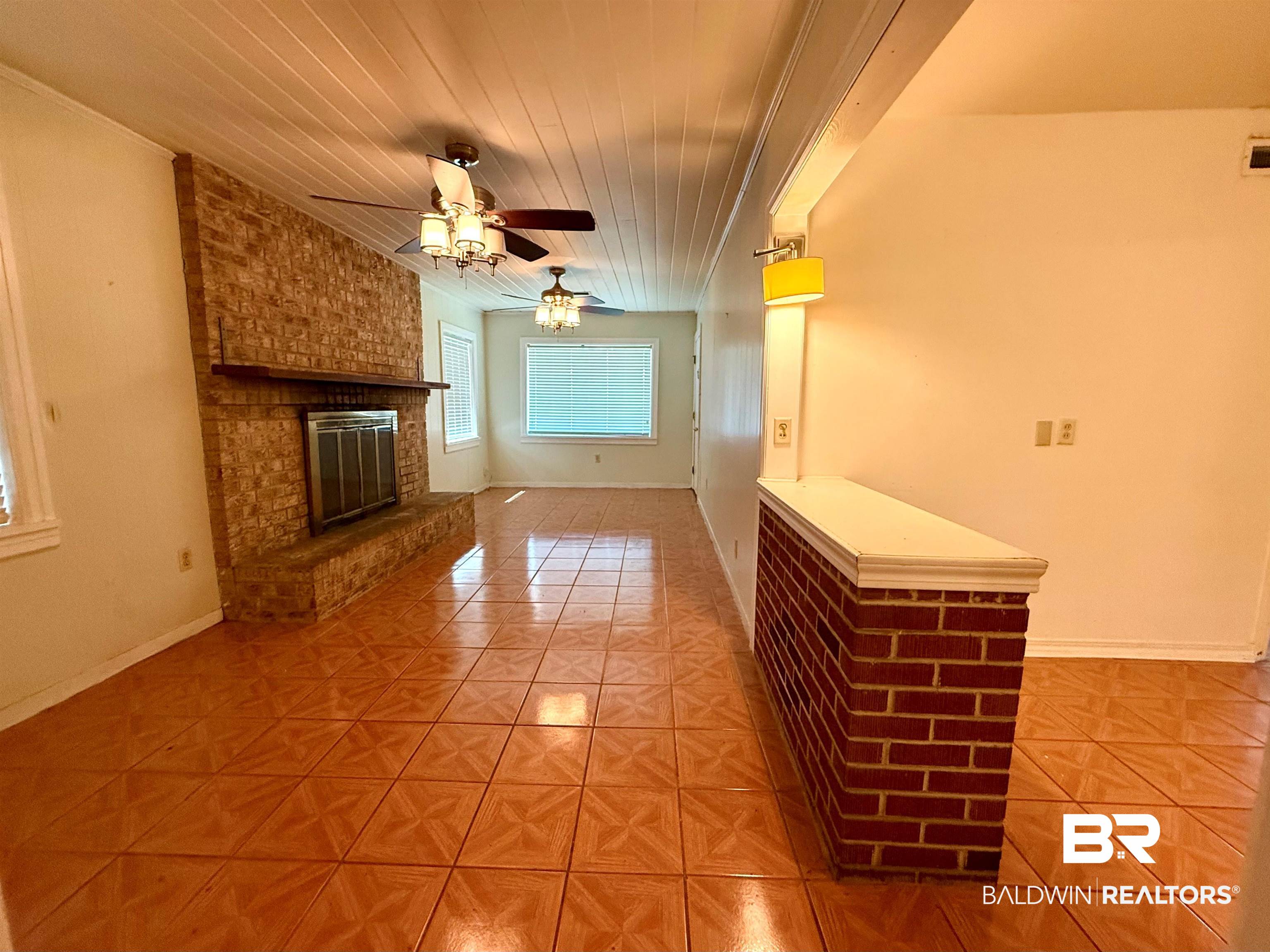 403 Sutherland Drive Mobile, AL 36611 - Photo 2 of 8 Unfurnished living room with light tile patterned flooring, wood ceiling, ceiling fan, a brick fireplace, and baseboards