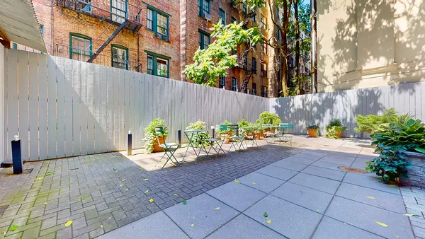 a view of a backyard with plants and a bench