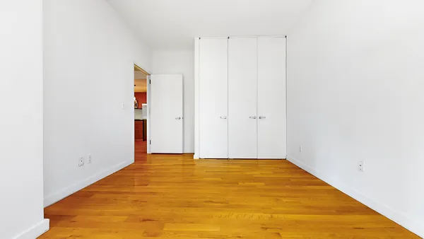 a view of a room with wooden floor and window