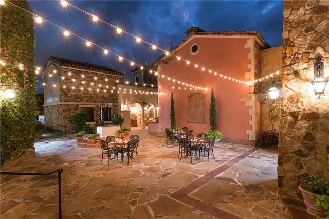 a view of a patio with dining table and chairs with potted plants and a barbeque
