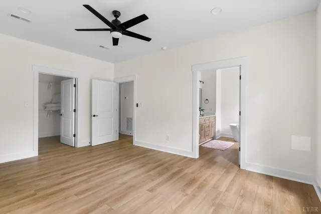 an empty room with a window and a fan