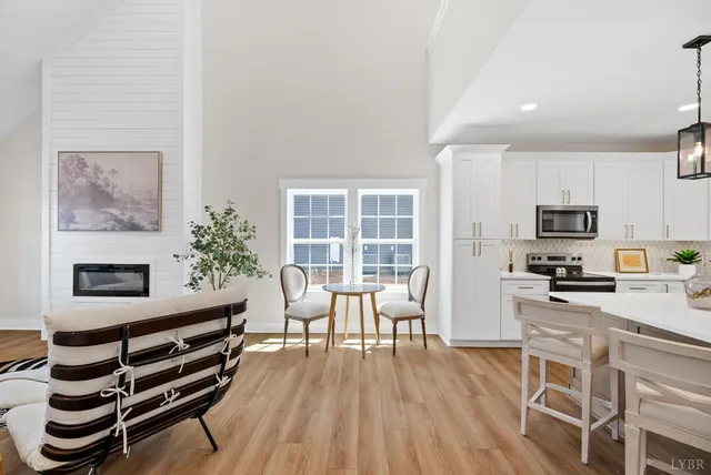a kitchen with stainless steel appliances a stove a table and chairs in it