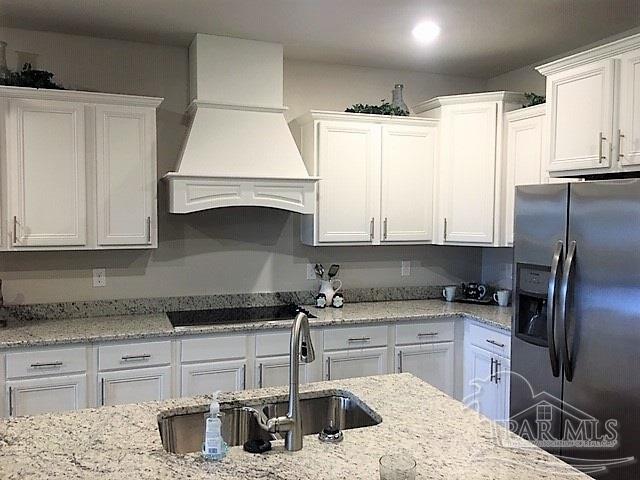5636 Blake Lane Milton, FL 32571 - Photo 5 of 27 a kitchen with granite countertop a sink stove and refrigerator