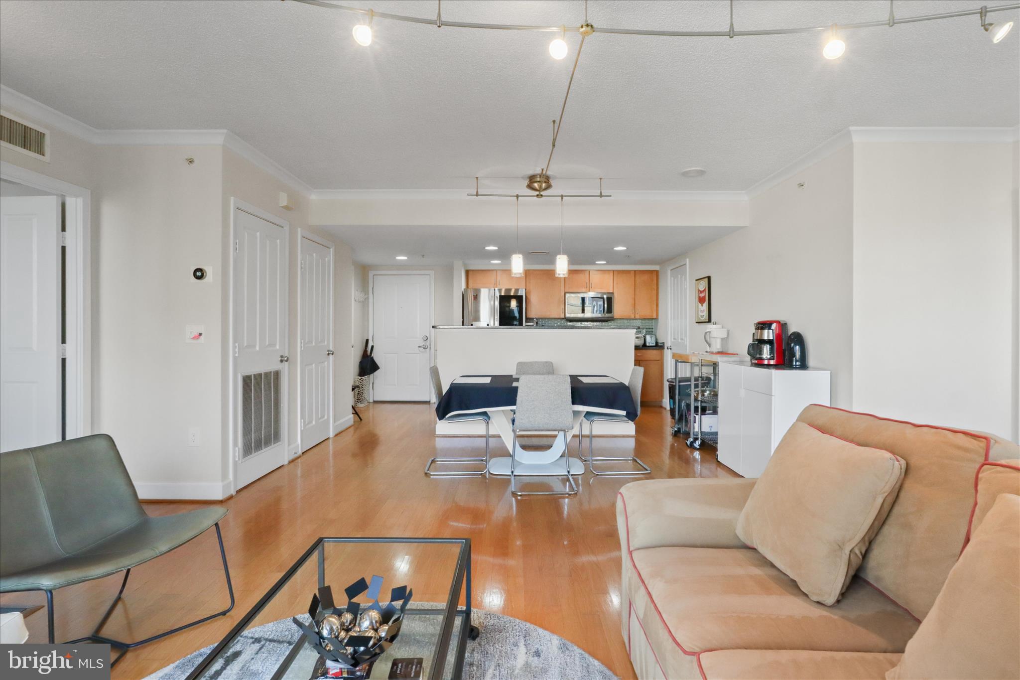 1220 North Fillmore Street, Unit 909 Arlington, VA 22201 - Photo 36 of 38 a living room with furniture and a dining table with kitchen view
